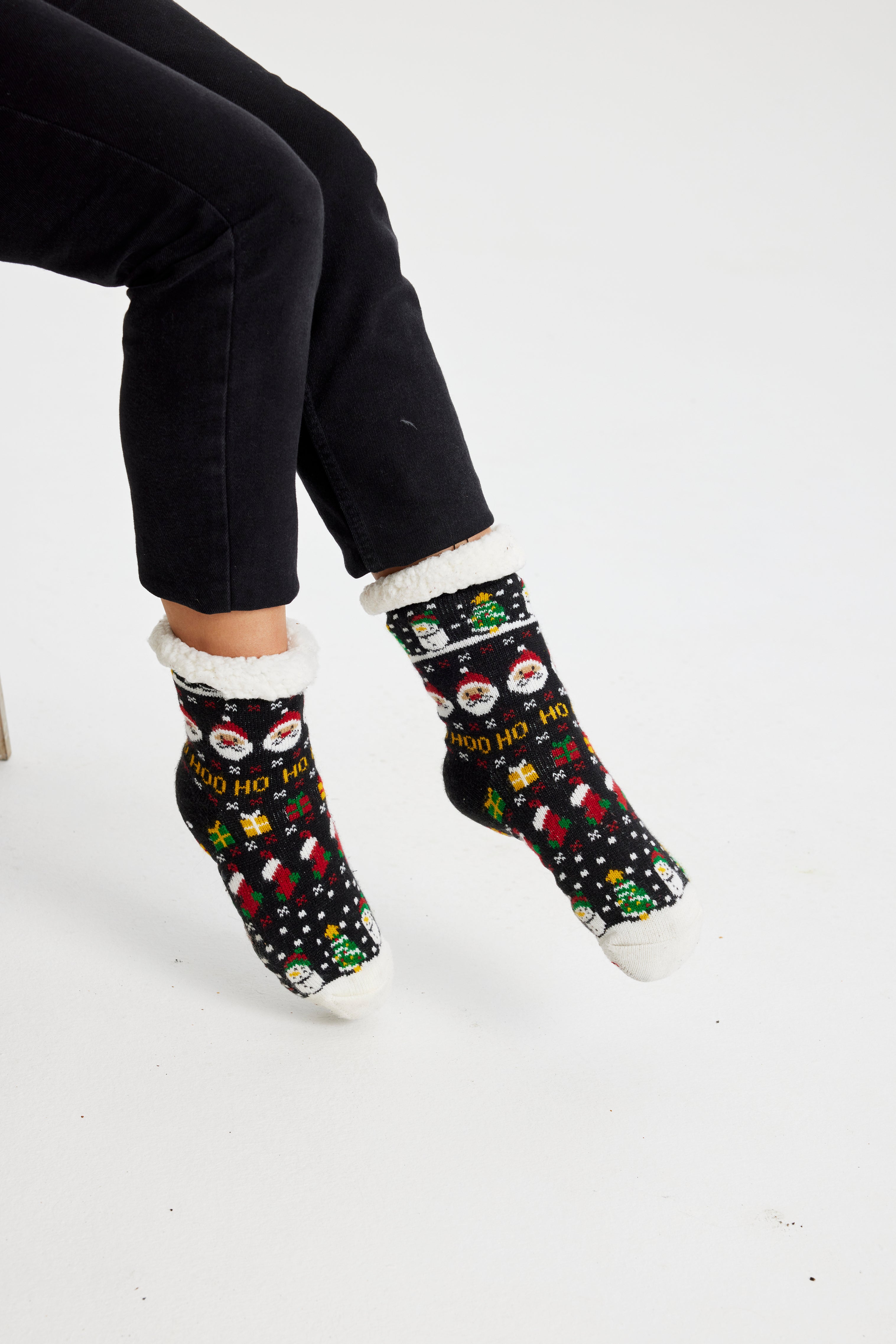 Et par fødder med sorte julesokker på.